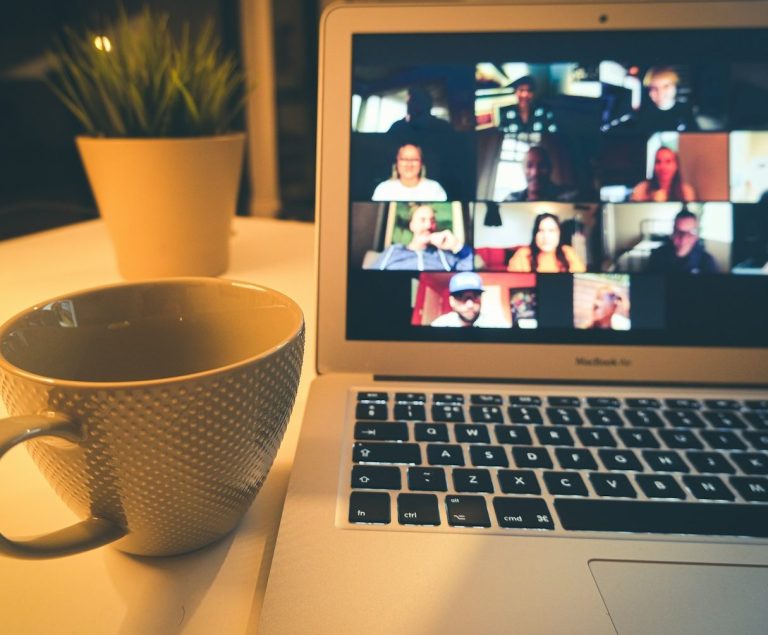Le rendez-vous des Leaders - Workshop Un ordinateur portable affichant une réunion en ligne avec plusieurs participants et une tasse de café.